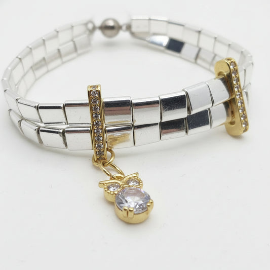 silver and gold tila bracelet featuring polished hematite beads and sparkling zircon details.
